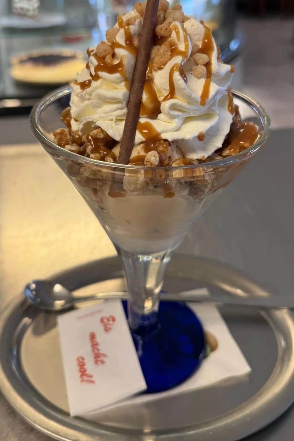 Eisbecher mit Sahne, Karamellsauce, Krokant und Waffelröllchen