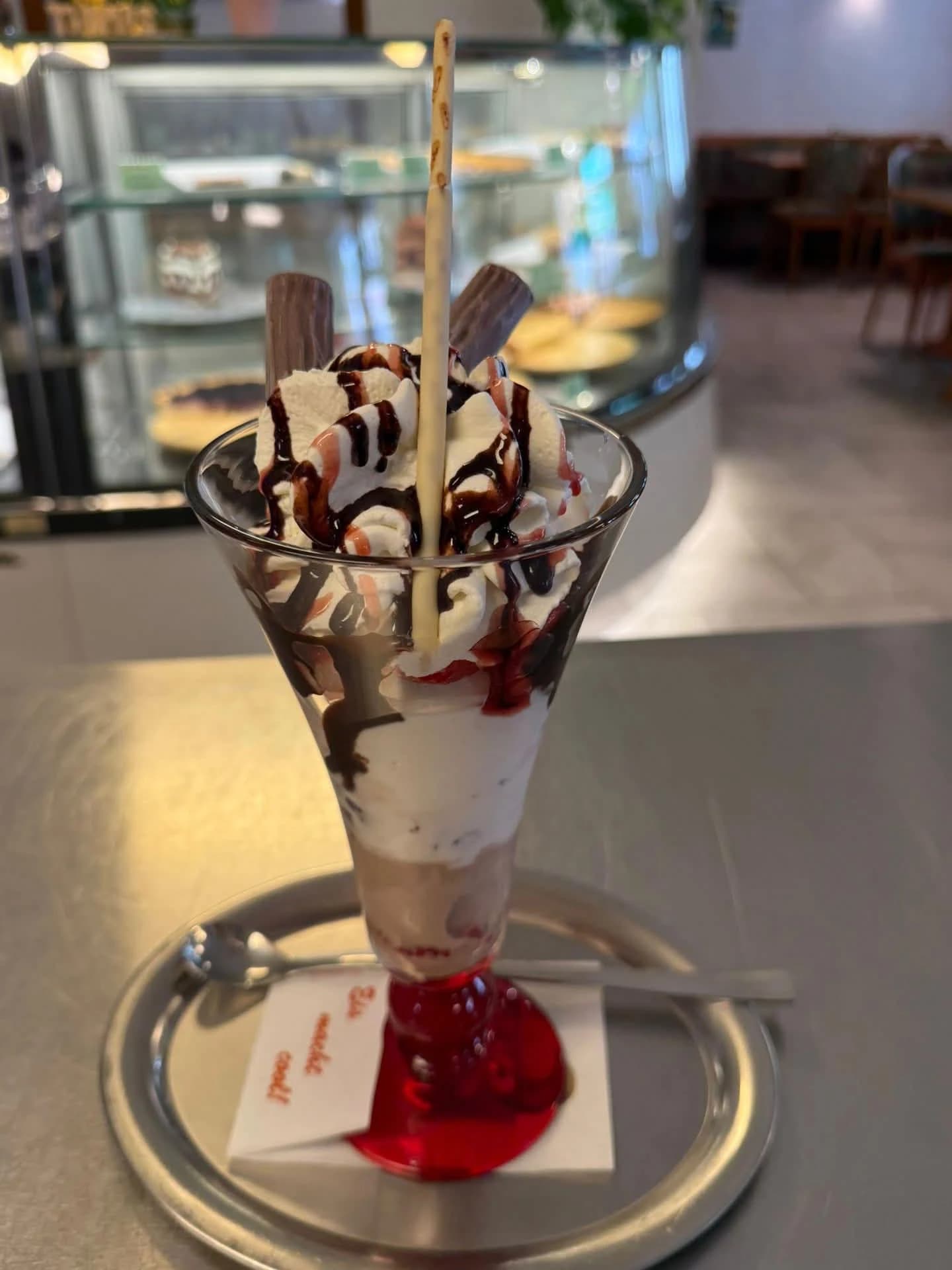 Eisbecher mit Sahne, roter Sauce und Schokolade