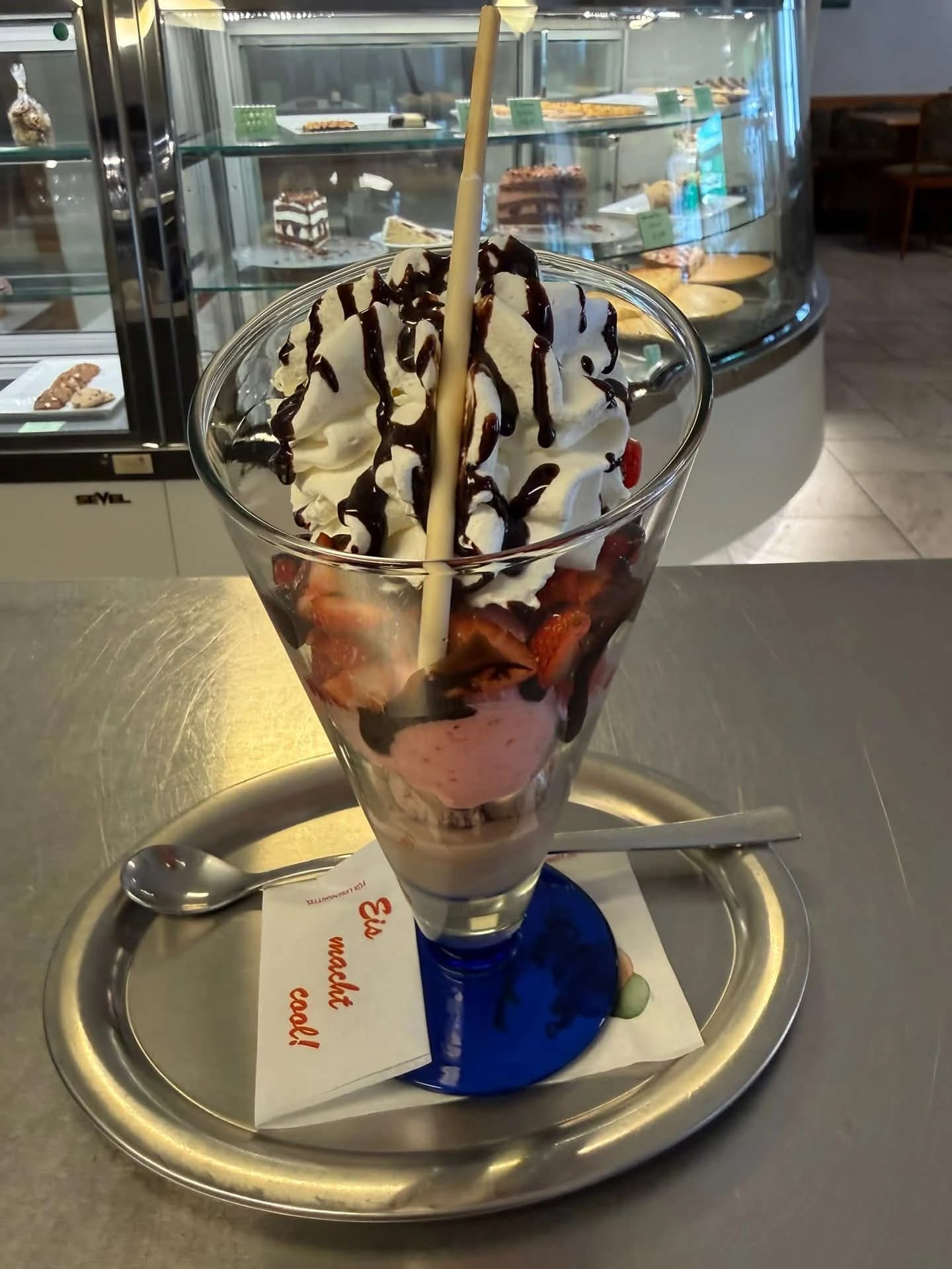 Eisbecher mit Sahne, roten Früchten und Schokosauce