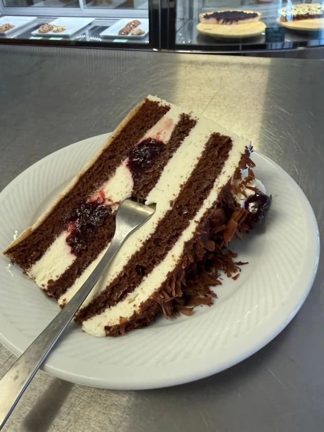 Zwei Stück Sahnetorte mit Kirschen und Schokoraspeln auf einem Teller